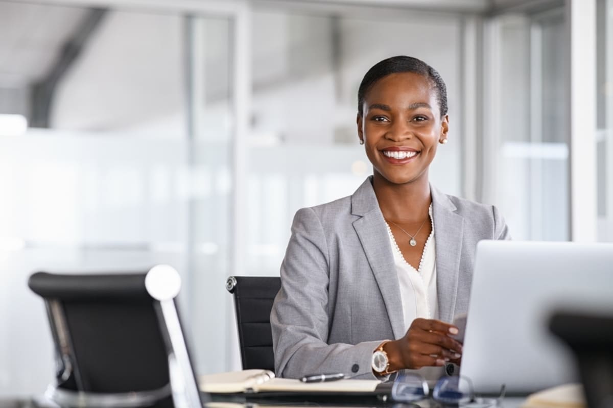 Happy businesswoman sitting at her desk and smiling