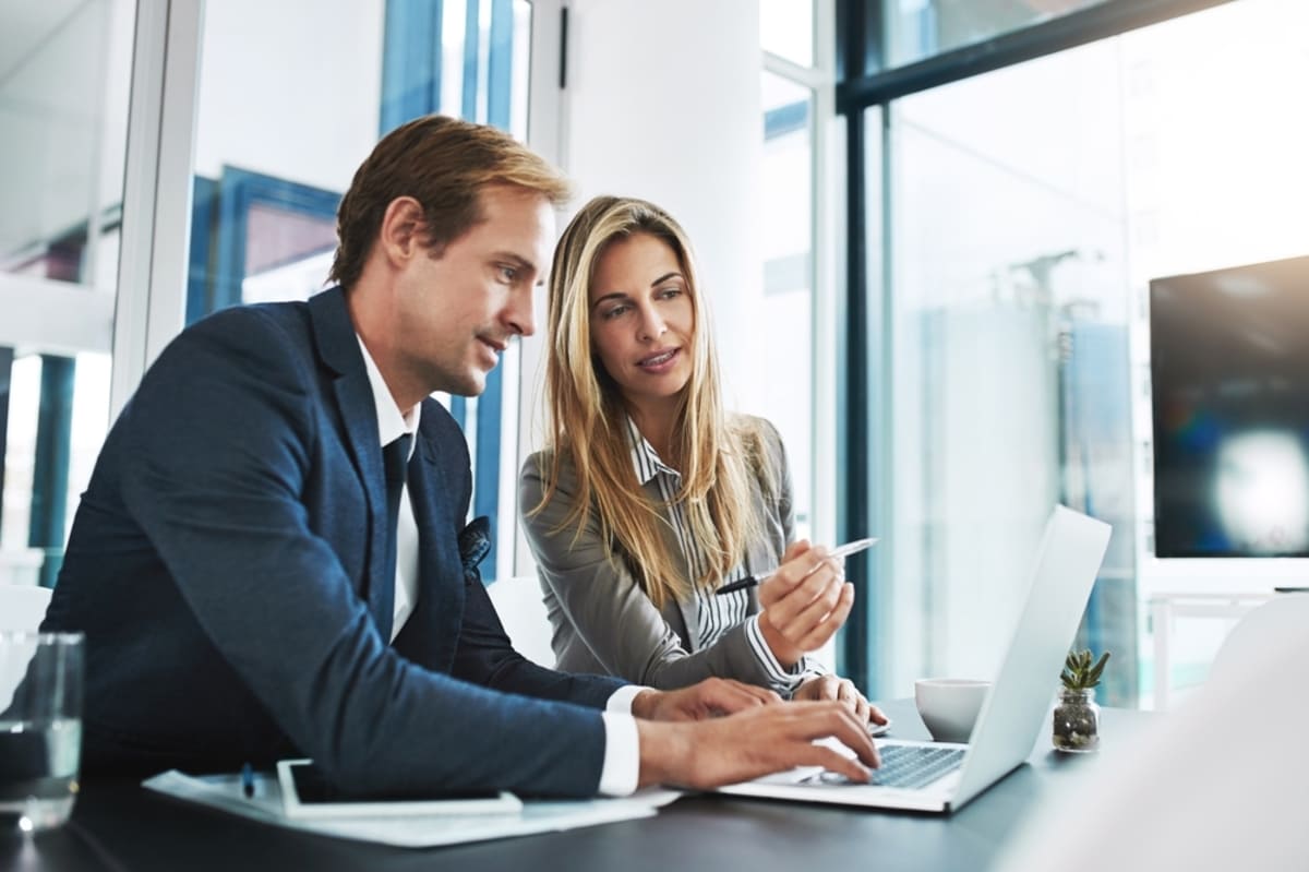 Man and woman talk about information on a laptop, property management consulting services concept-1