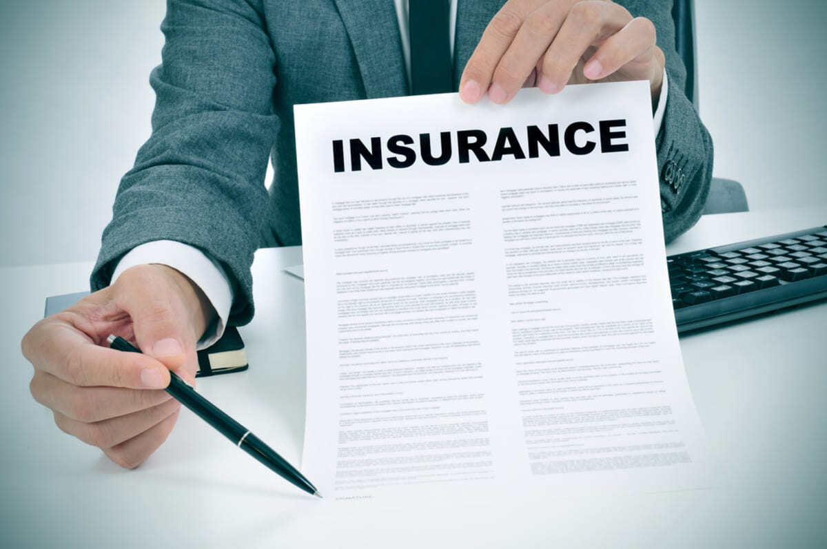 Someone holding a document that says insurance