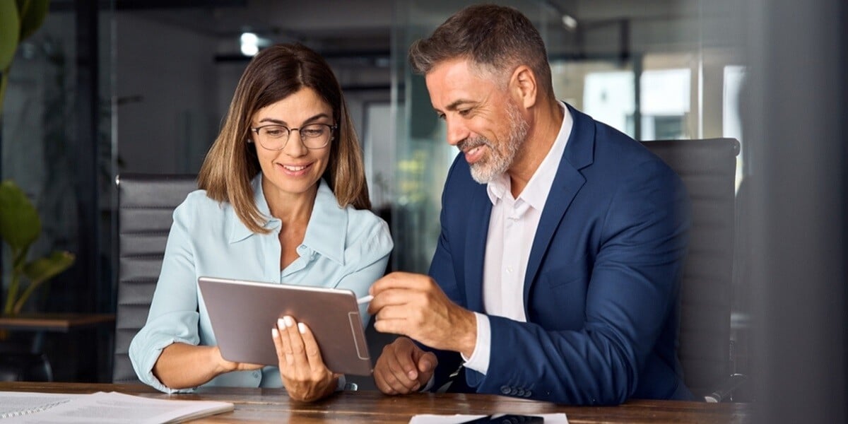 Two professionals looking at a tablet